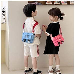 Vue de dos d'enfants portant des mini sacs bandoulière en toile bleu ciel et rose