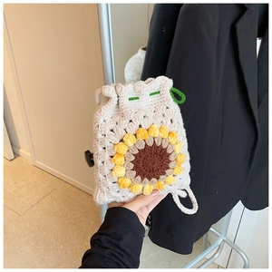 Close-up of handmade sunflower crochet crossbody bag with drawstring and knit texture
