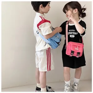 Sac bandoulière enfant en toile rose et bleu avec boucle réglable et poche frontale