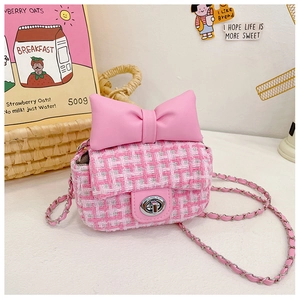 Detail of pink plaid tweed girls' bag with a large leather bow and metal chain strap