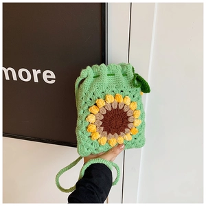 Detail of handmade crochet sunflower crossbody bag with green knit texture and drawstring