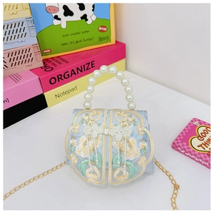 Detail of light blue kids' bag with gold floral embroidery and pearl handle