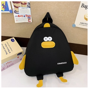 Vue détaillée du sac à dos canard noir avec ailes jaunes dans un décor chaleureux