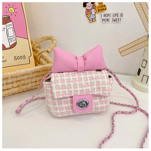 Detail of pink plaid kids crossbody bag featuring a large bow and silver metal clasp