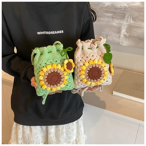 Close-up of handmade sunflower crochet bags with detailed stitch texture and leaf drawstring