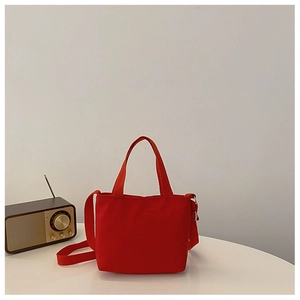 Red canvas tote bag for kids on white table with vintage radio prop background