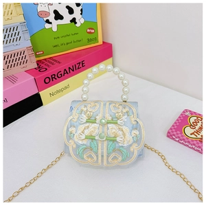 Detail of vintage blue mesh kid handbag with floral embroidery and pearl handle