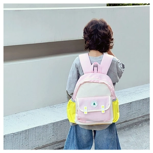 Vue détaillée d'un sac à dos enfant rose et blanc avec écusson d'arbre sur un modèle
