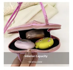 Vue détaillée de l'intérieur du sac cœur rose métallisé avec rangement de maquillage