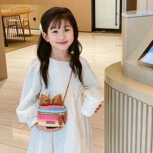 Child rainbow woven crossbody bag with brown bow detail and metal chain strap