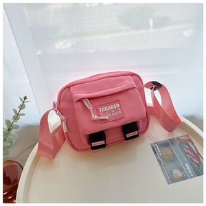 Gros plan détaillé du sac bandoulière rose en toile pour enfants avec boucle réglable