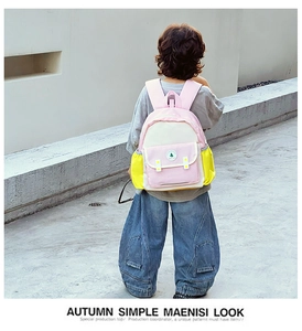 Sac à dos enfant avec panneaux contrastés rose et jaune et détail du logo en extérieur