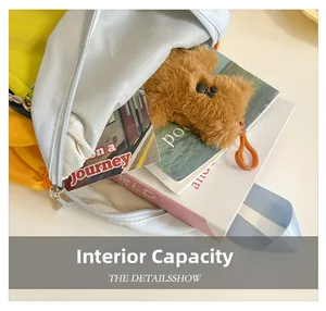 Top view of color-block kids backpack showing internal capacity with books and plush toy