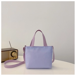 Detail of a purple nylon crossbody bag for kids with adjustable strap on white background