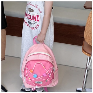 Detail eines rosa Kinderrucksacks mit bunten Perlen und Kordelzug-Überkreuzdesign