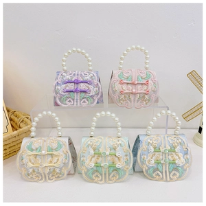 Detailed collection of silk bags with floral embroidery, knots and pearl handles