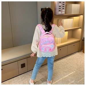 Rear view of a girl wearing the pink mermaid princess backpack in a home library setting