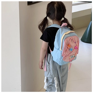 Detail eines Kinderrucksacks mit Sternanhängern und pinkfarbenen Kordelzügen