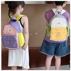 Rear view of two children wearing color-block backpacks with adjustable straps for school