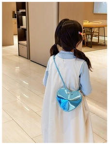 Vue détaillée d'une fille portant un sac à bandoulière en forme de cœur bleu