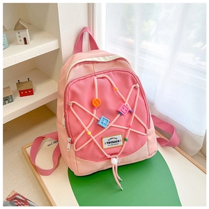 Detail eines rosa Kinderrucksacks mit bunten Sternperlen und elastischen Kordeln