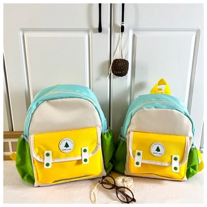 Comparaison de deux tailles de sacs à dos colorés en nylon avec écusson Good Luck