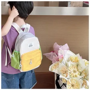 Rear view of a child wearing a color-block nylon backpack in white, yellow, and green