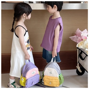 Detail showing two kids wearing colorful patchwork backpacks in purple and beige tones