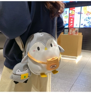 Detail of penguin-shaped crossbody bag with soft plush texture and mini charm