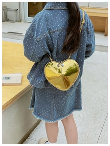 Vue arrière d'un enfant portant un sac bandoulière coeur doré brillant effet miroir