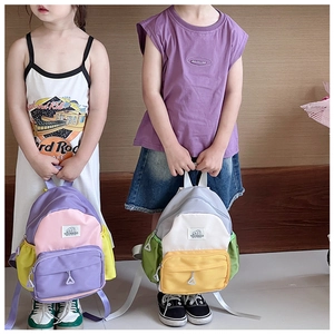 Detail of color-block kids backpacks featuring front zipper pockets and elastic side pouches