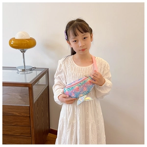 Girl wearing a colorful sequin fish tail waist bag with pink adjustable strap in a bright room