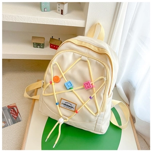 Detailansicht Kinderrucksack mit gelben Stern-Gummizügen und bunten geometrischen Anhängern
