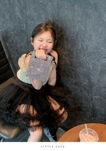 Close-up of sparkling silver rhinestone handbag with Little Cute text on kids fashion outfit