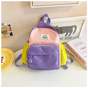 Detailed view of kids' color-block nylon backpack with pink, purple, and yellow panels