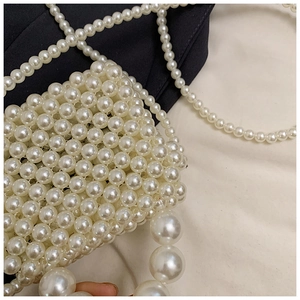Close-up of handmade mini pearl handbag with white beads and elegant top handle
