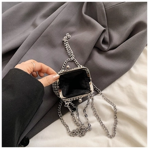 Detailed interior view of a sparkling rhinestone mini purse with silver chain and metal clasp
