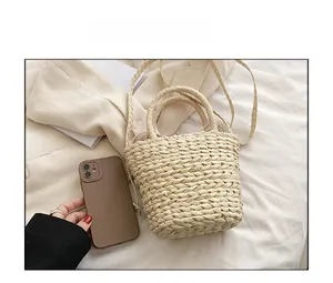 Straw bucket bag size comparison with smartphone showing interior drawstring liner