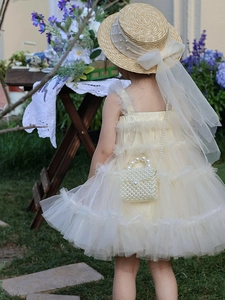 Detailed close-up of handmade white pearl handbag paired with yellow tulle dress