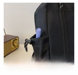 Detailansicht der Seitentasche mit Kordelzug und Kunststoffverschluss am schwarzen Rucksack