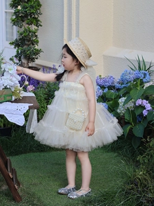 Close-up of a mini girl shoulder bag with pearl handle in a garden setting