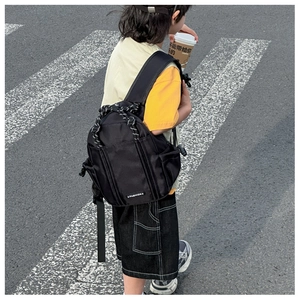 Detail eines schwarzen Nylon-Rucksacks mit Kordelzug-Design und modischem Textiletikett