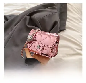 Detail of pink patent leather mini bag with quilted stitching and flower buckle