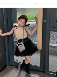 Detail of child model wearing a sparkling silver sequin crossbody bag and tutu dress