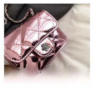 Close-up of pink patent leather quilted bag with silver floral lock and metal chain