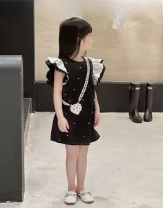 Détail d'un mini sac en perles en forme de cœur assorti à une robe pour fille