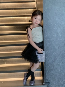 Little girl in polka dot top and tutu with sparkly handbag and Mary Jane shoes