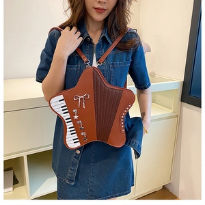Detail of star-shaped accordion bag with piano key patterns and butterfly metal charms