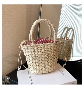 Close-up of handmade straw bucket bag with striped drawstring lining and woven texture