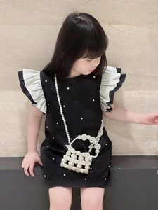 Close-up of pearl embellishments and white ruffle pleated sleeves on girls dress